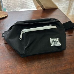Never used black HERSCHEL fanny pack with a red and white striped inside